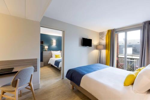 Pokój hotelowy z łóżkiem, biurkiem i oknem w obiekcie BEST WESTERN La Porte des Châteaux w mieście Meung-sur-Loire