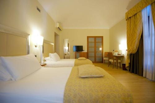 a hotel room with two beds and a desk at Best Western Crystal Palace Hotel in Turin
