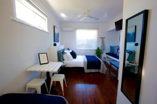 a bedroom with a bed and a table and chairs at Tea Gardens Hotel in Tea Gardens