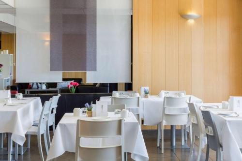 a dining room with white tables and white chairs at Best Western Park Hotel Geneve-Thoiry in Thoiry