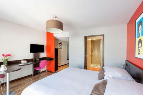 a bedroom with a white bed and a desk and chair at Best Western Park Hotel Geneve-Thoiry in Thoiry