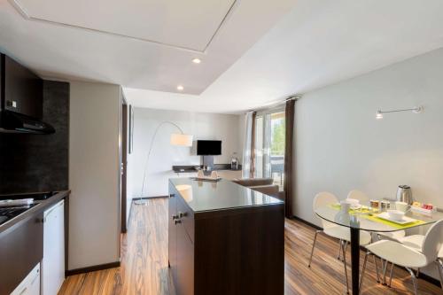 a kitchen with a table and a dining room at Best Western Park Hotel Geneve-Thoiry in Thoiry