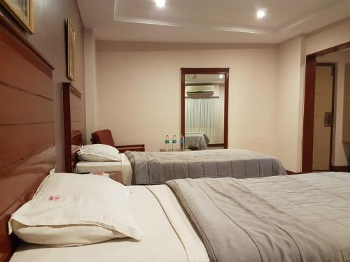 a hospital room with two beds and a mirror at Hotel Subhalakshmi Palace in Kāraikkudi