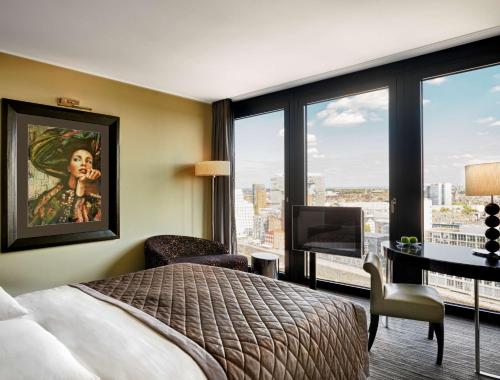 a hotel room with a bed and a large window at Hyatt Regency Dusseldorf in Düsseldorf