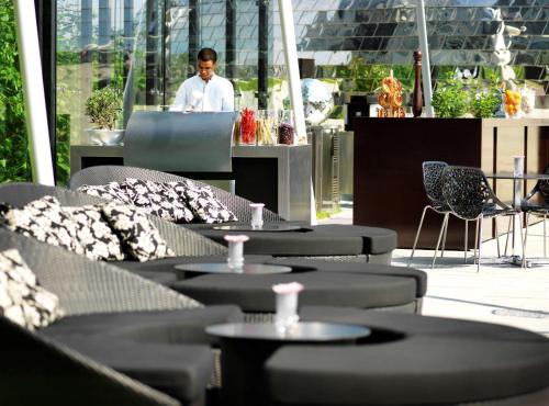 a man standing in front of a table in a restaurant at Hyatt Regency Dusseldorf in Düsseldorf