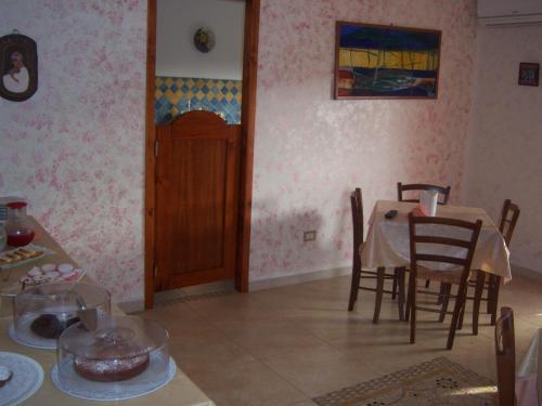 a dining room with a table and a table and chairs at Sa Marina in La Caletta