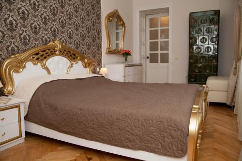 リヴィウにあるLuxury Lviv Apartmentのベッドルーム1室(金枠の大型ベッド1台付)