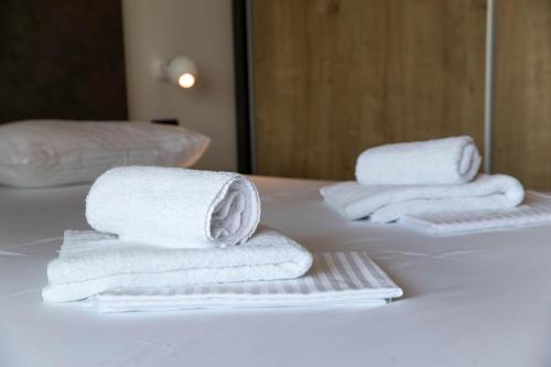 drei Stapel Handtücher auf einem weißen Tisch in der Unterkunft Apartments Agape in Crikvenica