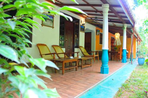 a porch with chairs and a table on a house at Senura Home Stay in Sigiriya