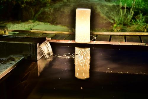 a candle sitting on top of a pool of water at Tateshina Park Hotel in Chino