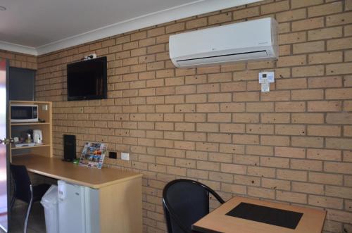 a room with a brick wall with a air conditioner at Sunray Motor Inn in Toowoomba