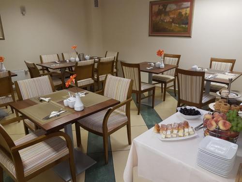 a restaurant with tables and chairs with a plate of food at Willa Biala Lilia Old Town in Gdańsk