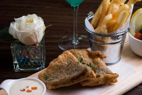 a cutting board with a sandwich and french fries at Green Ville Laguna Hotel in Sung Noen