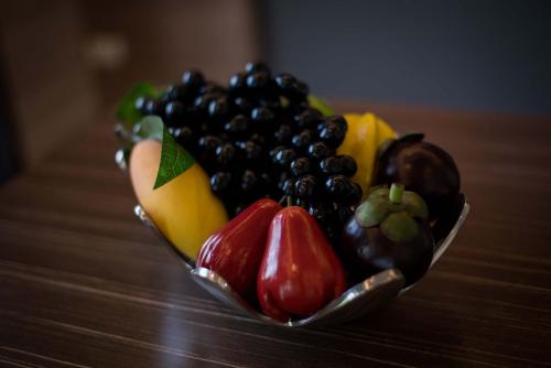 a bowl of fruit sitting on top of a table at Green Ville Laguna Hotel in Sung Noen