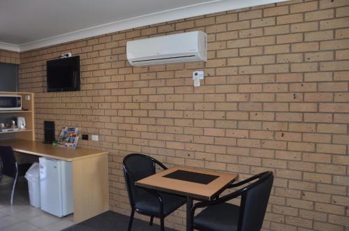 a room with a table and chairs and a brick wall at Sunray Motor Inn in Toowoomba