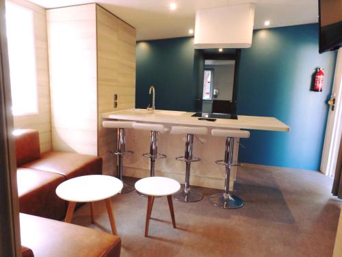 a kitchen with a counter and a sink and stools at Villaggio Dei Fiori in Sanremo
