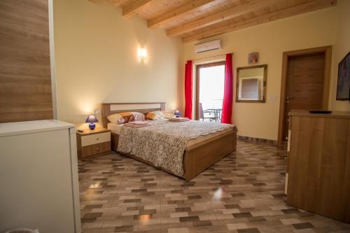 a bedroom with a bed and a window with red curtains at Nice place in Rovinj