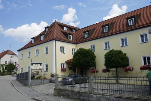 a large yellow house with a black car parked in front at Landhaus Krone in Steinach