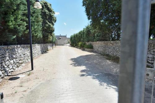 マーリエにあるMasseria i Cocciの石壁のレンガ道路