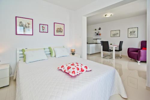 a white bedroom with a bed with a pillow on it at Apartments Dorijan in Beautiful House in Hvar