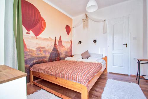 メゼーケヴェシュトにあるThe Weekend House - Zsóryのベッドルーム1室(壁に絵画が描かれたベッド1台付)