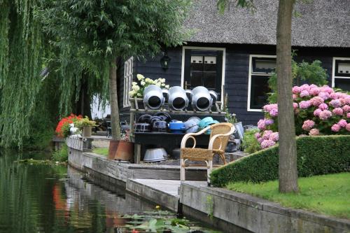 a garden filled with lots of flowers next to a dock at Hotel de Harmonie in Giethoorn
