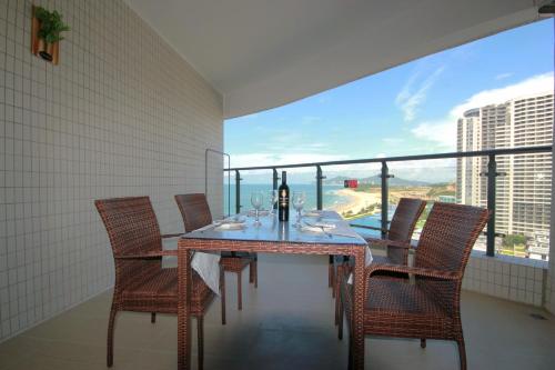 a dining room with a table and chairs and a large window at Coast-Inn Hailing Island in Yangjiang