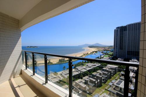 a balcony with a view of the beach and buildings at Coast-Inn Hailing Island in Yangjiang