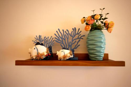 a shelf with a vase and flowers on it at Coast-Inn Hailing Island in Yangjiang