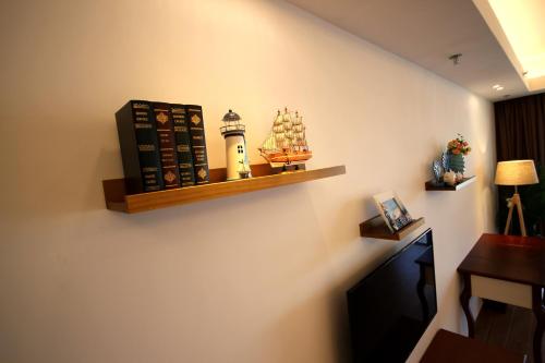 a room with a shelf with a book and a boat on a wall at Coast-Inn Hailing Island in Yangjiang