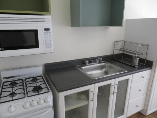 a kitchen with a sink and a microwave at Magic Castle Hotel in Los Angeles