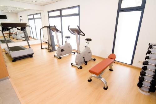 a gym with treadmills and exercise equipment on the floor at Blaumar Hotel in Salou