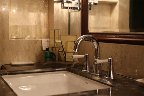 a sink in a bathroom with a mirror at Shangri-La Manzhouli in Manzhouli