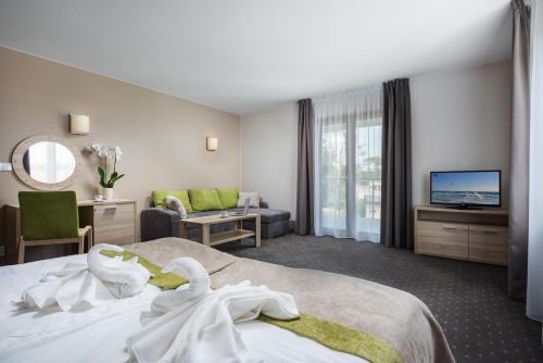 een hotelkamer met een bed en een televisie bij Hotel Szafir in Jastrzębia Góra