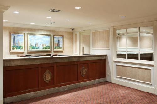 a large kitchen with a counter and two windows at Millennium Knickerbocker Chicago in Chicago