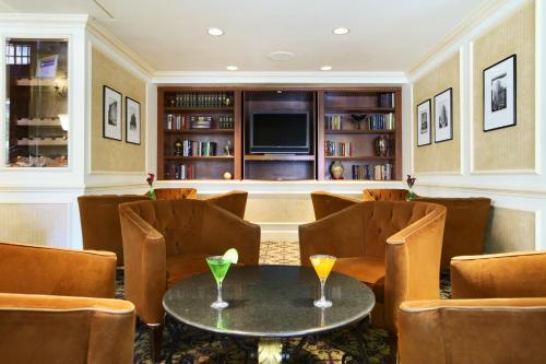 a room with a table and chairs and a television at Millennium Knickerbocker Chicago in Chicago
