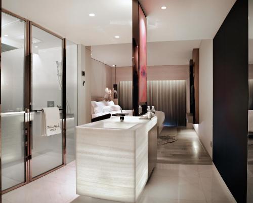 a bathroom with a white sink and a mirror at Naumi Hotel in Singapore
