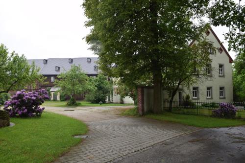 ein weißes Haus mit einem Baum und einer Auffahrt in der Unterkunft Ferienhof Schricker in Marktleuthen