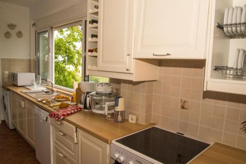 a kitchen with white cabinets and a counter top at Olea Escape Villa in an Olive Estate in Gythio