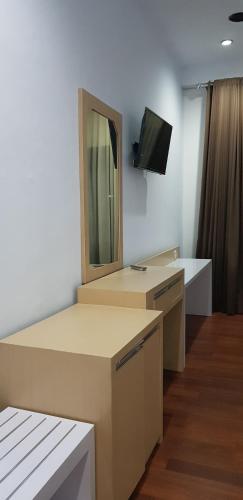 a room with a mirror and a tv on the wall at Mandalawangi Hotel Syariah in Tasikmalaya