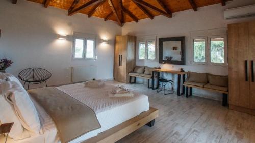 a bedroom with a large bed and a table and chairs at Olea Escape Villa in an Olive Estate in Gythio