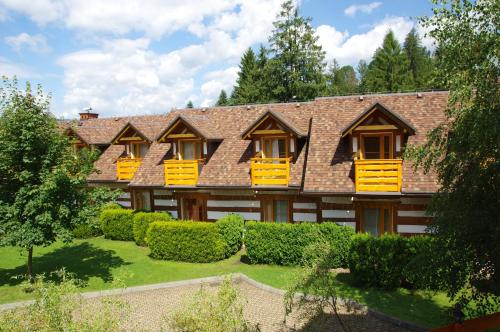 Casa grande con ventanas amarillas y arbustos en Kamratowo, en Wisła