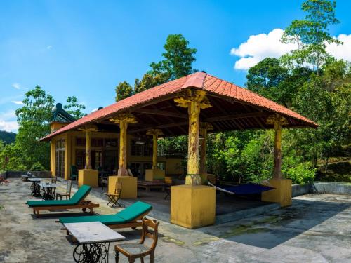 a pavilion with tables and chairs in front of a building at The Kandy Samadhicentre in Kandy