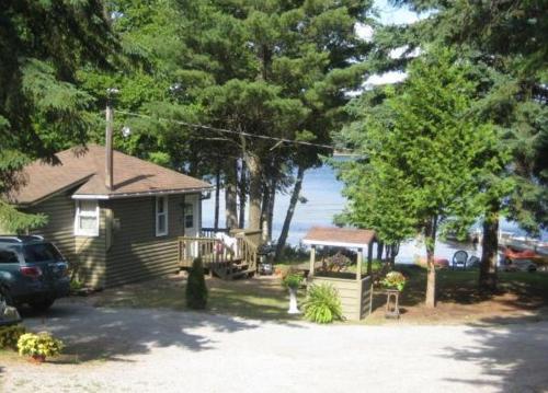 a house with a car parked in a driveway at Cloverleaf Cottages in Oxtongue Lake