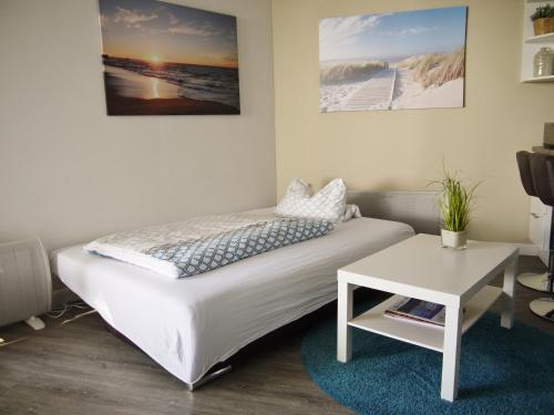 ein Schlafzimmer mit einem weißen Bett und einem Tisch in der Unterkunft Oceanbreeze in Scharbeutz