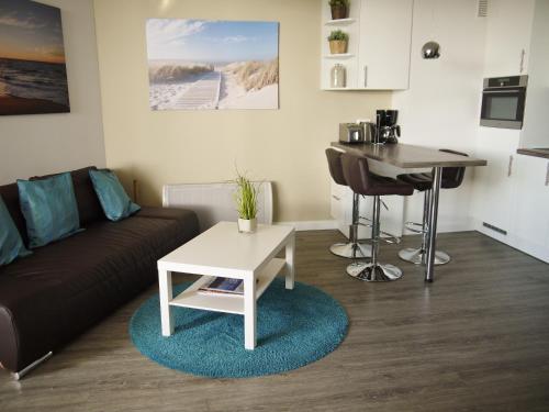 ein Wohnzimmer mit einem Sofa und einem Tisch in der Unterkunft Oceanbreeze in Scharbeutz