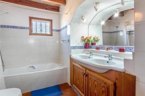Un baño con lavabo, bañera y espejo. en Villa Suari, en Pollensa