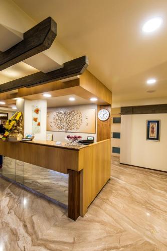 a lobby with a counter and a clock on the wall at Hotel Park Central Koregaon Park in Pune