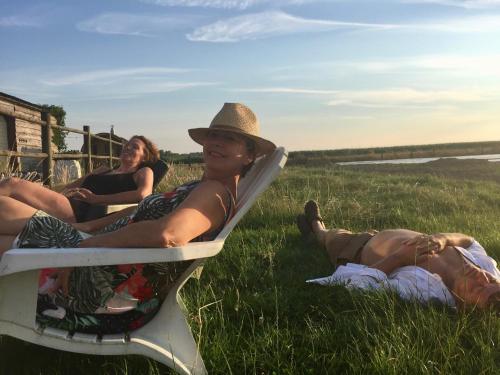two people sitting on a chair in the grass at Maison Marie in Poperinge