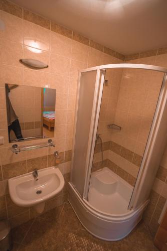 a bathroom with a shower and a toilet and a sink at Penzión Weinerovka Varín in Žilina